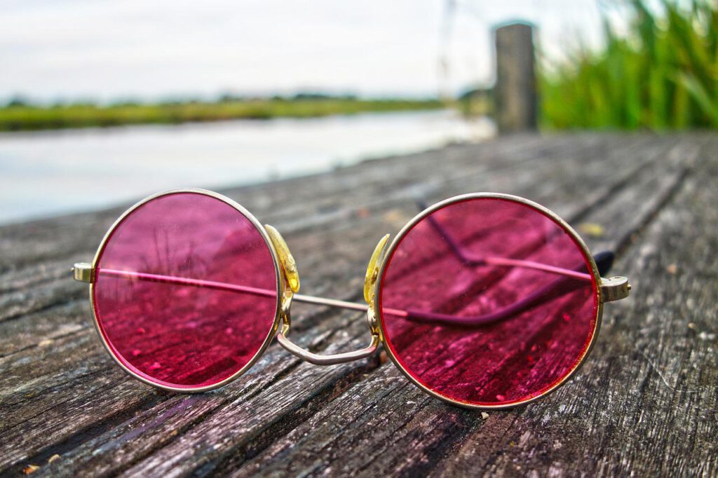 Okulary przeciwsłoneczne leżące na drewnianym stoliku na zewnątrz